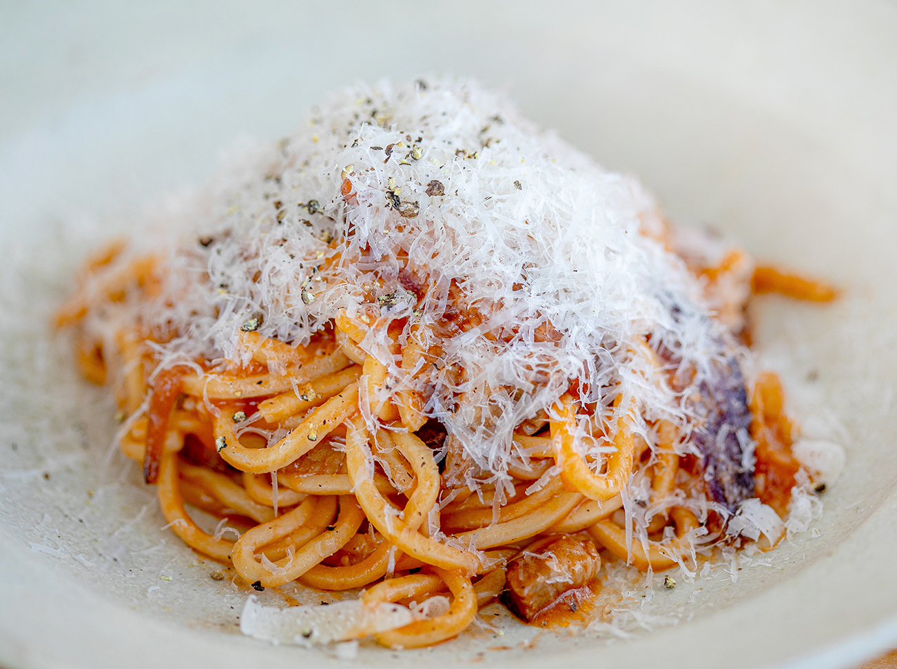 日替わりのパスタメニュー。この日は自家製たけし豚のベーコンと玉ねぎのトマトソースパスタ。麺はもちもちと歯ごたえがあり、ベーコンの燻した香りが口の中に広がる